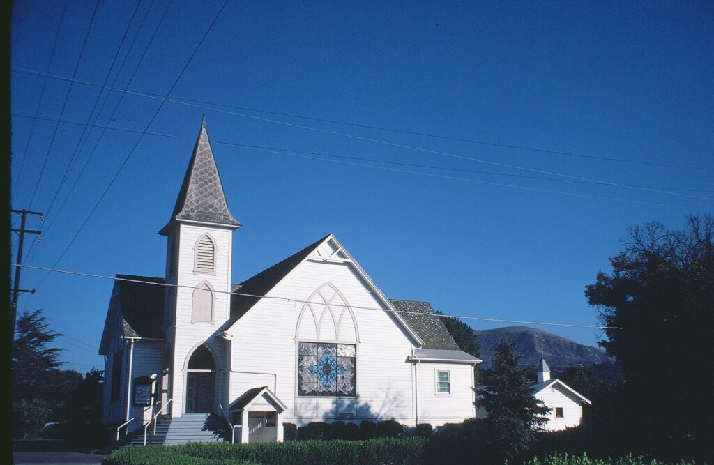 Bardsdale Methodist Church in a sunny setting, featuring Gothic architecture and stained glass.