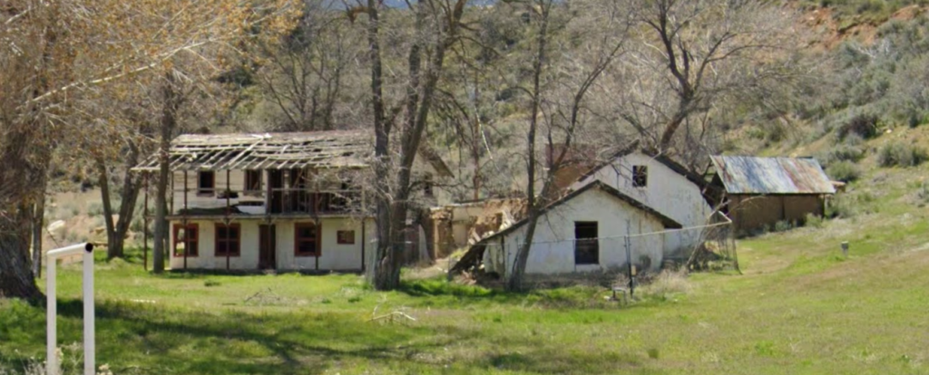Detailed view of adobe ruins with trees, April 2023.