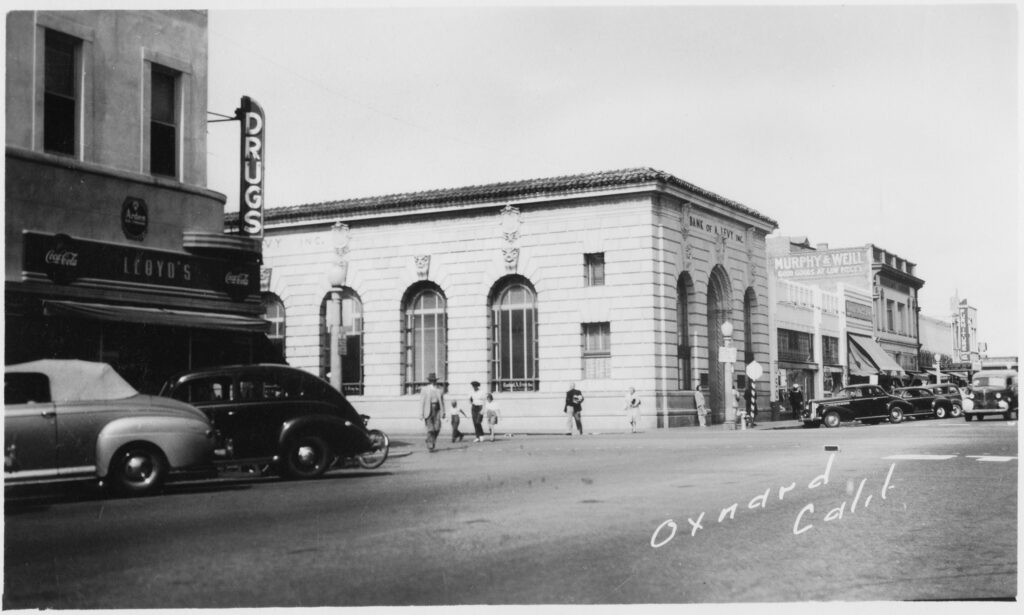 Black and white historical photo of Bank of A. Levy and surrounding Oxnard streetscape.