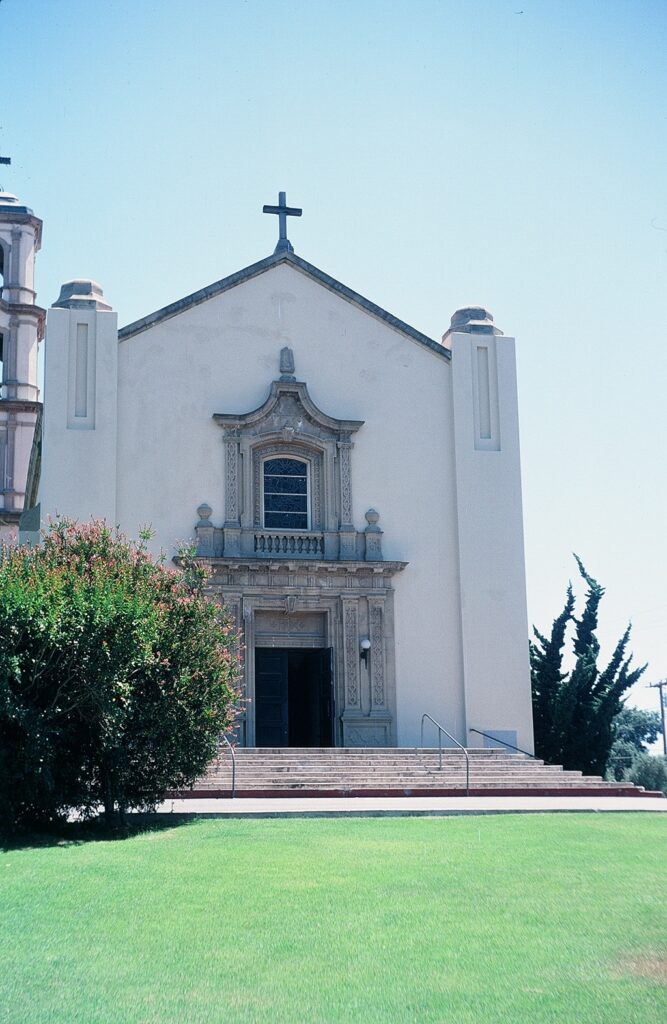 Front entrance of St. Mary Magdalen Church with detailed stonework and greenery, 1978.