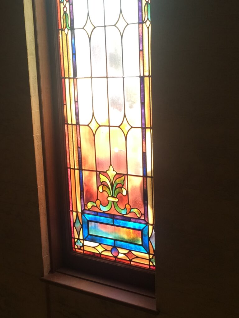 Interior view of stained-glass window with colorful geometric patterns.